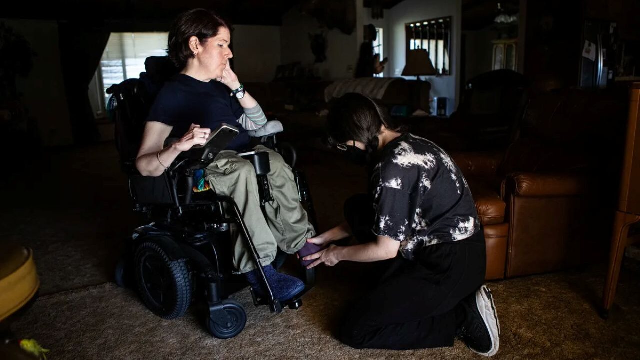 Image of a medical aide attending to a woman in a wheelchair