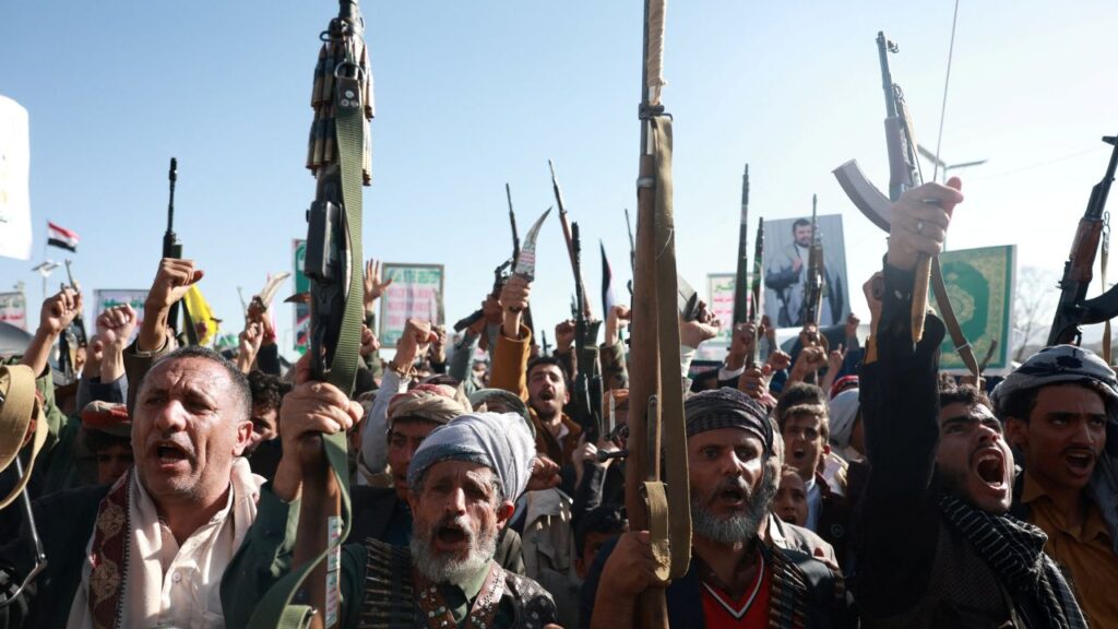 Image of Houthi supporters showing support for their soldiers by raising rifles into the air