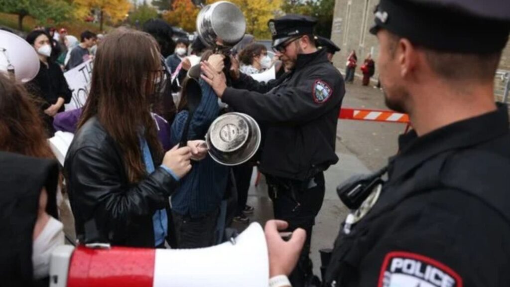 A Cornell University police officer holds back a protester as the school’s Board of Trustees met on campus in Ithaca, N.Y., on Friday, Oct. 16, 2026. In protests, statements, and open letters, some Cornell students and faculty members continued to express outrage this week at how the university had handled allegations of a gang rape at a fraternity house two years ago. (Lauren Petracca/The New York Times)