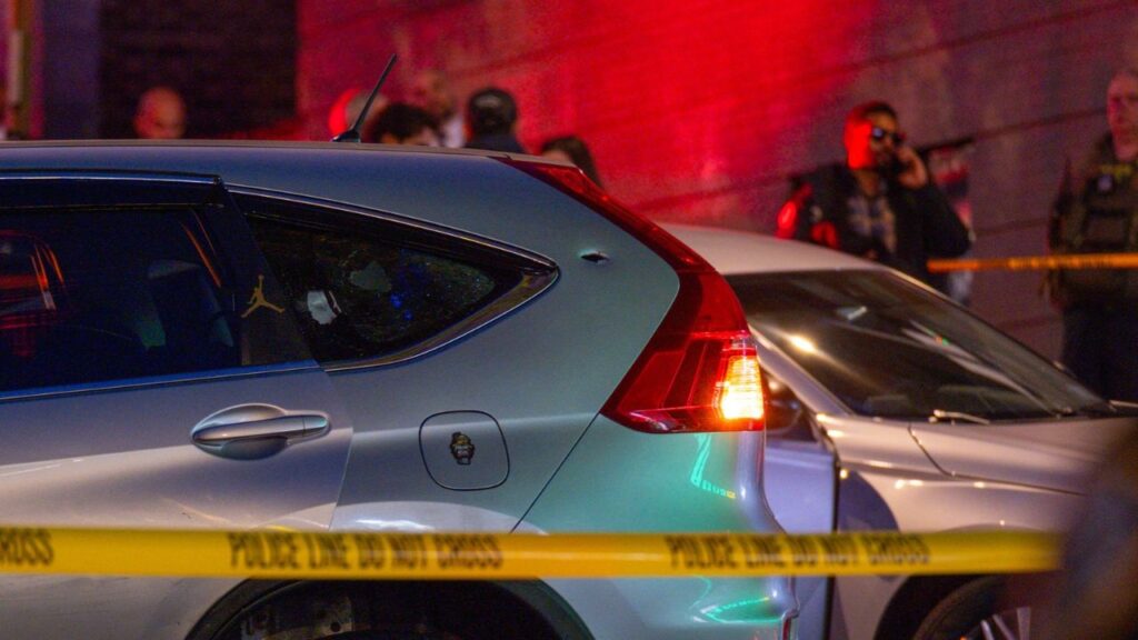 A bullet hole and a shattered window are seen on the car driven by a man who was shot by federal immigration agents in the Marble Hill neighborhood of New York on Thursday night, Oct. 8, 2026. A police spokesman said the person who was shot had been taken to a nearby hospital and was conscious and receiving medical attention. (Dakota Santiago/The New York Times)