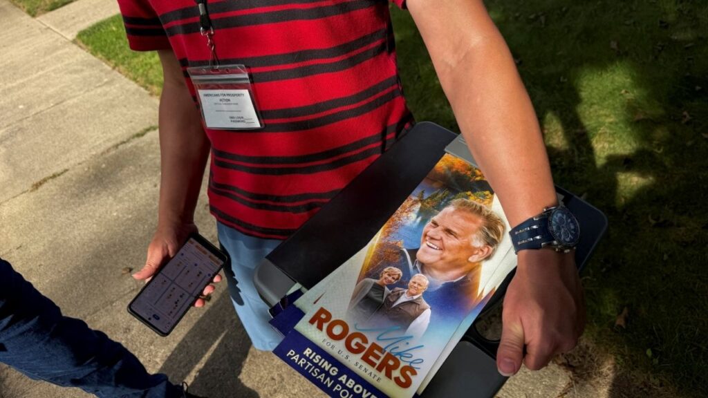 A canvasser for Americans for Prosperity Action, a conservative super PAC, holds a leaflet for Republican U.S. Senate candidate Mike Rogers while door knocking in Livonia, Michigan, U.S., September 14, 2026. Picture taken with a mobile phone. (Reuters File)
