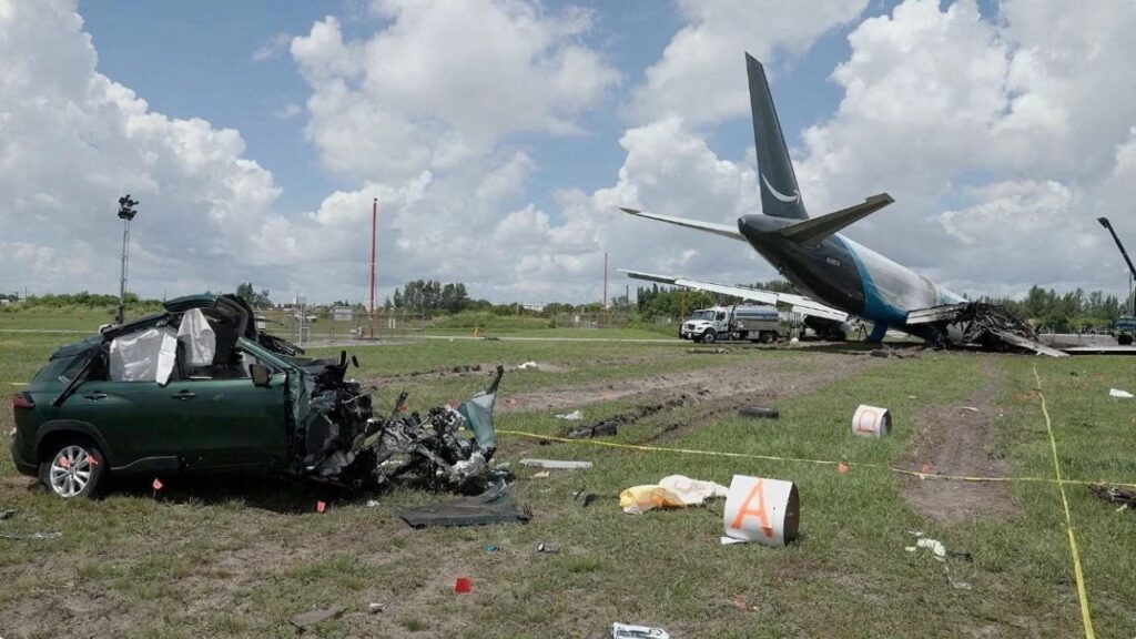 A damaged car next to the wreckage of an Amazon Prime Air cargo plane overran a runway at Miami International Airport, in Miami, Florida, U.S., in this screengrab obtained from a handout video released on September 8, 2026. (Reuters File)