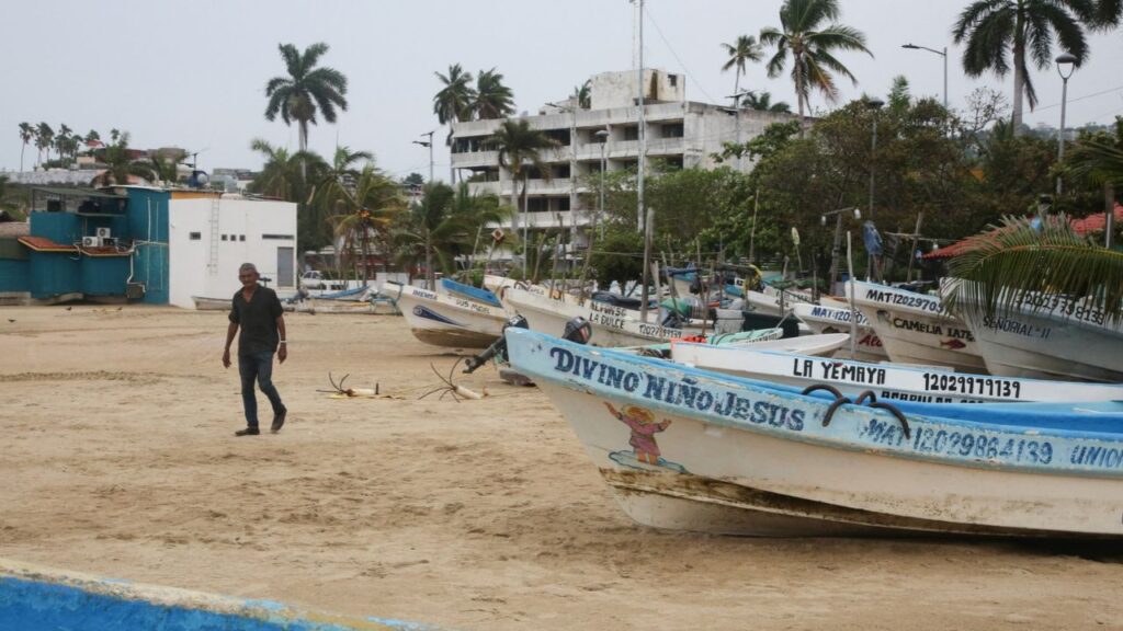 A man walks past fishing boats pulled from the sea as Hurricane Trudy moves parallel to Mexico's Pacific coast, threatening more rain and strong winds after recent deadly storms, in Acapulco, Mexico, October 15, 2026. REUTERS/Javier Verdin