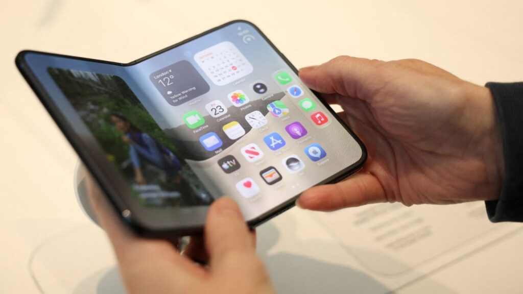 A person uses the new foldable Apple iPhone Duo, on its launch day at an Apple store, in London, Britain, October 23, 2026. REUTERS/Isabel Infantes