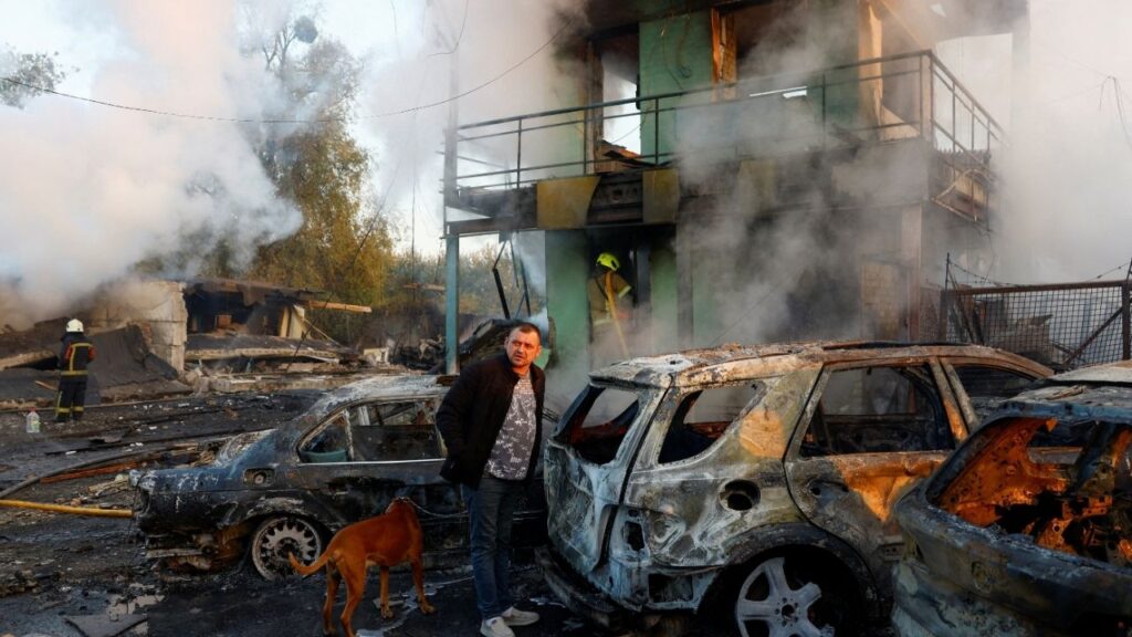A resident with a dog looks on at the site of private car garages hit by a Russian missile strike, amid Russia's attack on Ukraine, in Kyiv, Ukraine October 7, 2026. REUTERS/Valentyn Ogirenko TPX IMAGES OF THE DAY