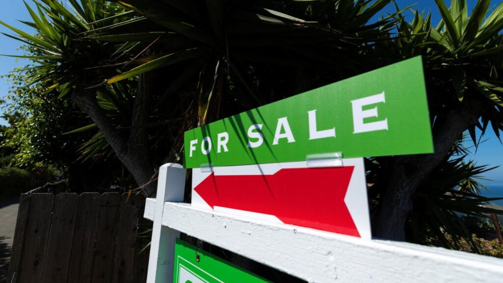 A residential real estate sign points to a home for sale in Encinitas, California, U.S., July 14, 2026. REUTERS/Mike Blake
