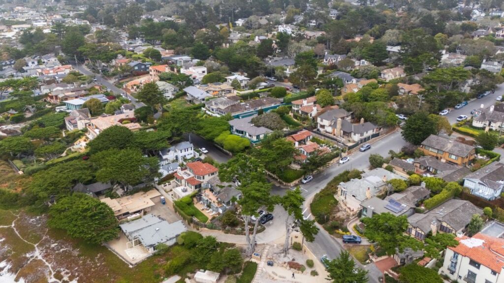 An aerial view of Carmel-by-the-Sea, Calif., which had gotten along without street address numbers for more than a century, Sept. 24, 2026. Driven by emergency response needs, the town, which has long guarded its eccentricities, reluctantly adopted street address numbers this summer. (Nic Coury/The New York Times)
