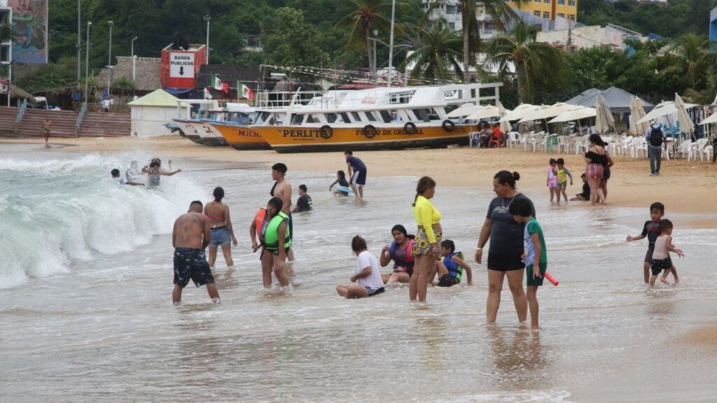 Beachgoers enjoy the shore as Hurricane Trudy moves parallel to Mexico's Pacific coast, threatening more rain and strong winds after recent deadly storms, in Acapulco, Mexico, October 15, 2026. REUTERS/Javier Verdin