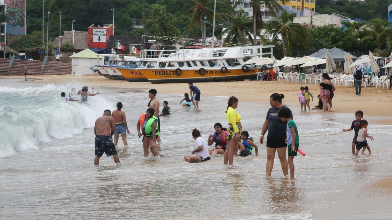Beachgoers enjoy the shore as Hurricane Trudy moves parallel to Mexico's Pacific coast, threatening more rain and strong winds after recent deadly storms, in Acapulco, Mexico, October 15, 2026. REUTERS/Javier Verdin