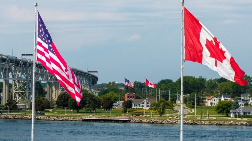 Canadian and U.S. flags fly on both sides of the St. Clair River near the Blue Water Bridge, connecting Sarnia, Ontario, and Port Huron, Michigan, in Sarnia, Ontario, Canada, September 2, 2026. REUTERS/Carlos Osorio