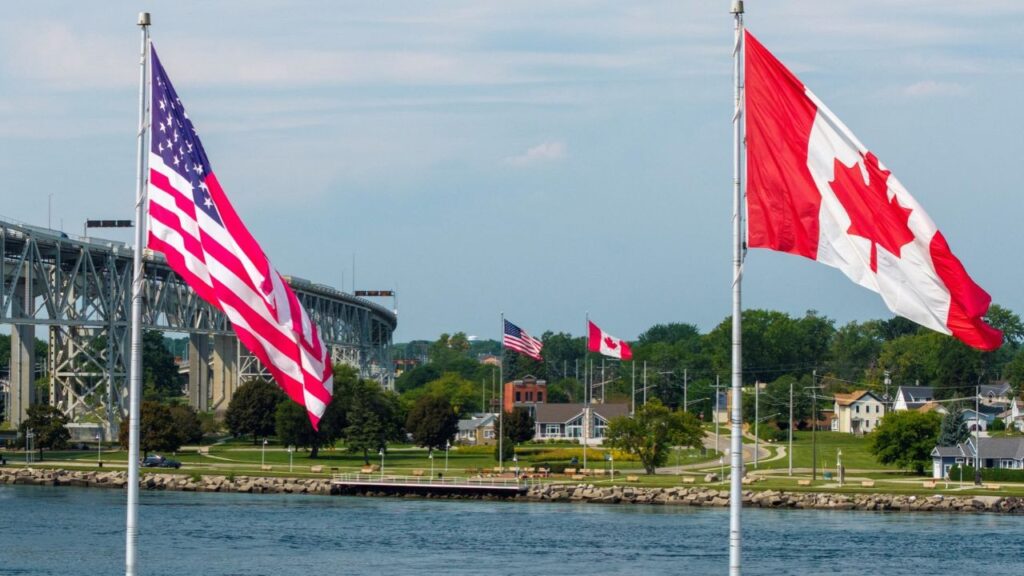 Canadian and U.S. flags fly on both sides of the St. Clair River near the Blue Water Bridge, connecting Sarnia, Ontario, and Port Huron, Michigan, in Sarnia, Ontario, Canada, September 2, 2026. REUTERS/Carlos Osorio