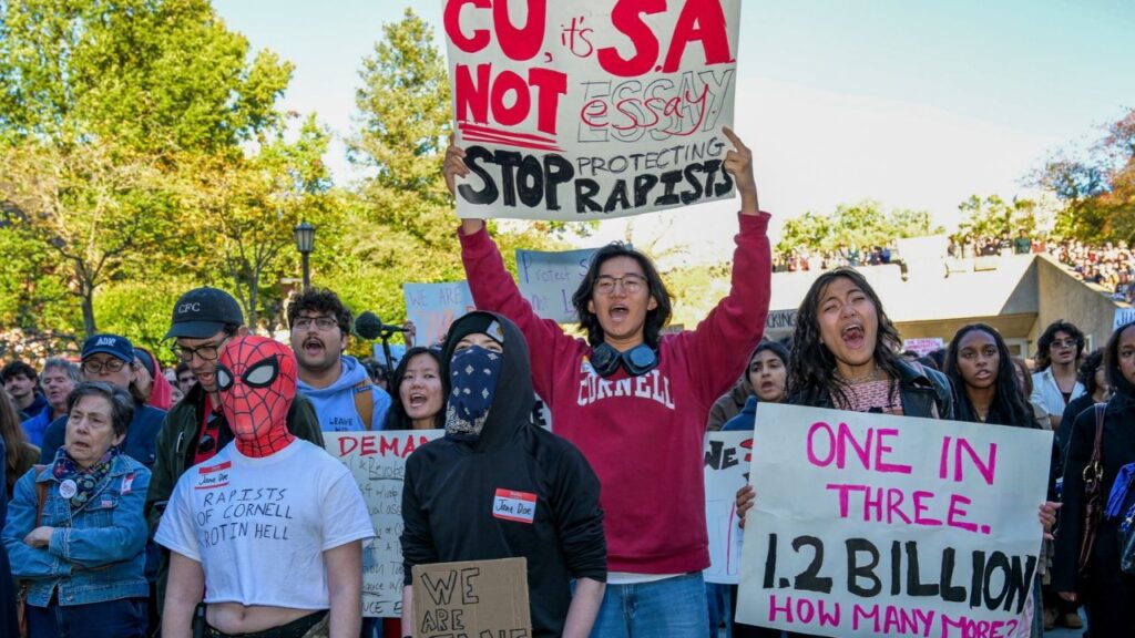 Demonstrators chant and hold signs during a protest over Cornell University's handling of the 2024 fraternity-house gang rape allegations on the Cornell campus in Ithaca, N.Y., on Monday, Oct. 5, 2026. (Heather Ainsworth/The New York Times)