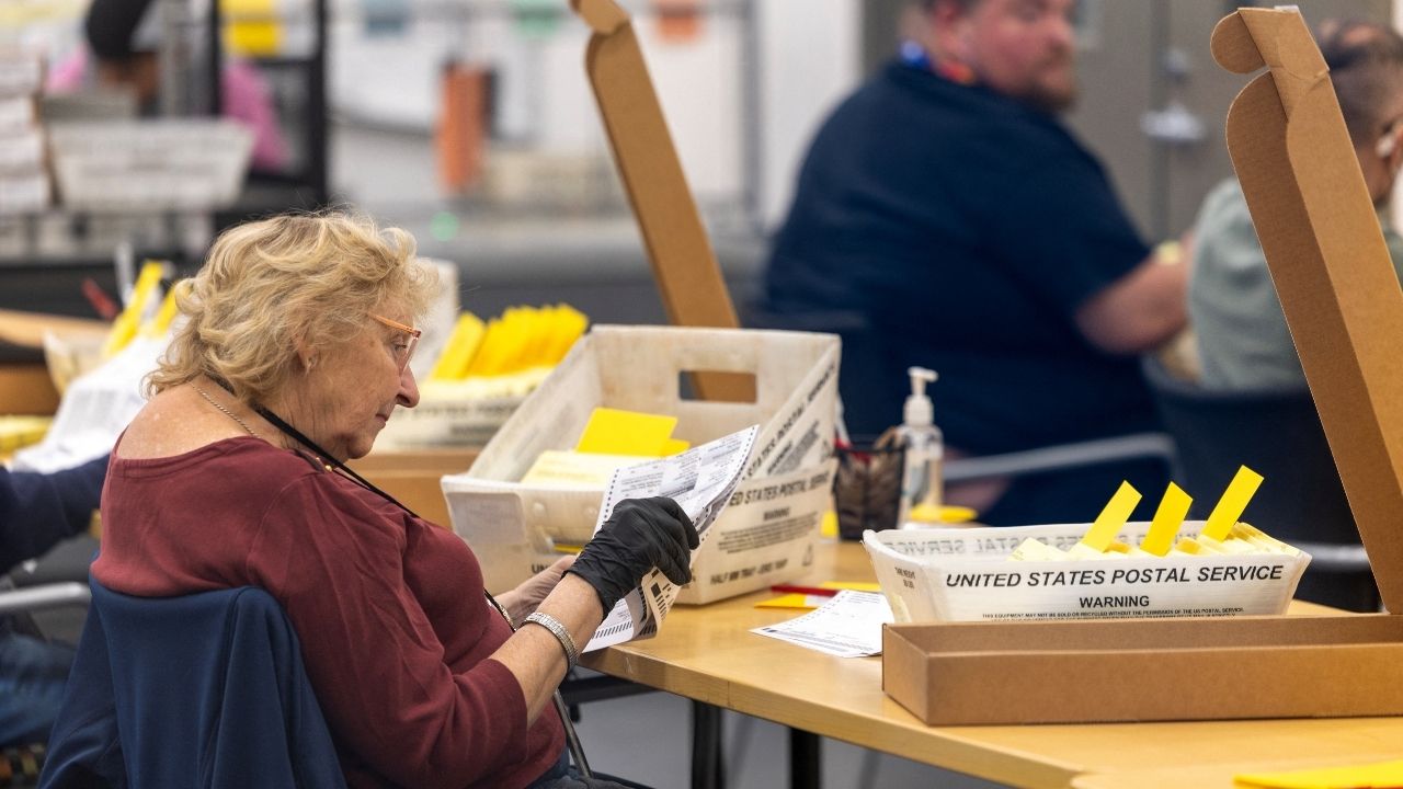 Election workers extract ballots as they help process mail-in ballots at the Registrar of Voters facility in San Diego, California, US, October 23, 2026. REUTERS/Mike Blake
