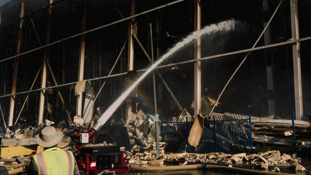 Firefighters battle a blaze at the cold storage facility Lineage Logistics in the Boyle Heights neighborhood of Los Angeles, June 22, 2026. State and local investigators executed a warrant on Tuesday, Oct. 6, 2026, to search the Boyle Heights building, which burned for days in June. A community group also sued the EPA to get environmental data. (Mark Abramson/The New York Times)