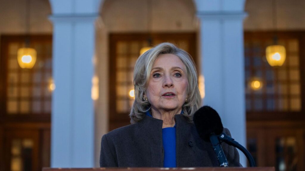 Former Secretary of State Hillary Clinton speaks to reporters in Chappaqua, N.Y., Feb. 26, 2026. With their podcast “High Stakes,” Clinton is teaming up with “Pivot” co-host Kara Swisher to break down the consequential battle for the House and the Senate in the midterm elections. (Hiroko Masuike/The New York Times)