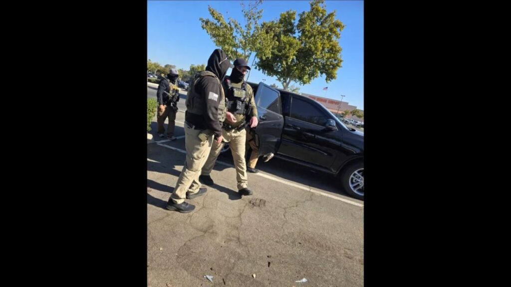 Image of masked ICE agents and a vehicle outside of a Home Depot in Madera, California