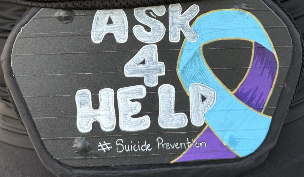Image of a Ask 4 Help message on the back of a football jersey