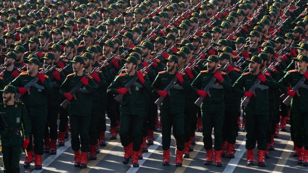 Image of hundreds of IRGC cadets in uniforms facing left and holding rifles in military parade fashion