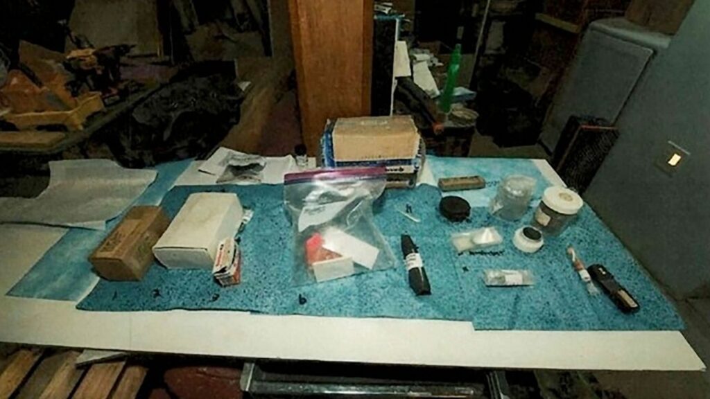 In an undated photo from the U.S. Attorney's Office for the District of Massachusetts, materials found in the basement of Jacob Miller and placed on blue laboratory mats by investigators. Miller has pleaded guilty to charges of importing and selling plutonium obtained from Russia and mailing the shipments as well as other toxic materials to customers in the U.S. and abroad, prosecutors said. (U.S. Attorney's Office for the District of Massachusetts via The New York Times)