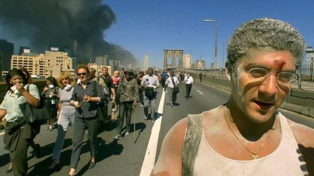 Joseph Sylvester, right, who worked at the World Financial Center, joins people using the Brooklyn Bridge to flee the site of the attacks on the World Trade Center, in New York, Sept. 11, 2001. Newly released records show that although residue from the World Trade Center towers coated the inside of homes, officials allowed residents to return with scant guidance. (Andrea Mohin/The New York Times)