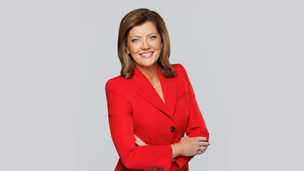 Image of Norah O'Donnell in a red dress with arms folded at the waist