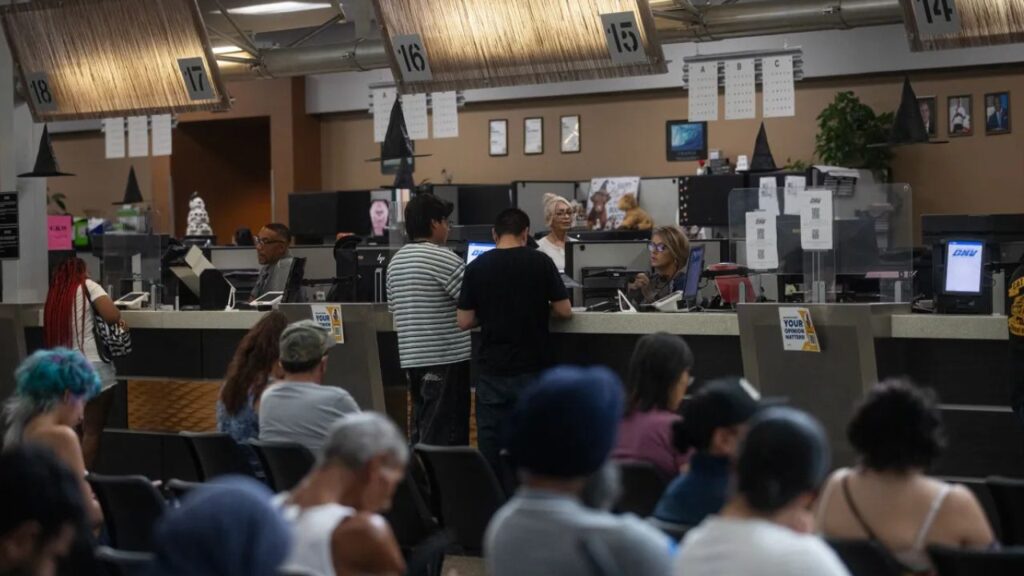 People stand at the counter of the Department of Motor Vehicles in Fresno on Oct. 2, 2026. Photo by Larry Valenzuela for CalMatters