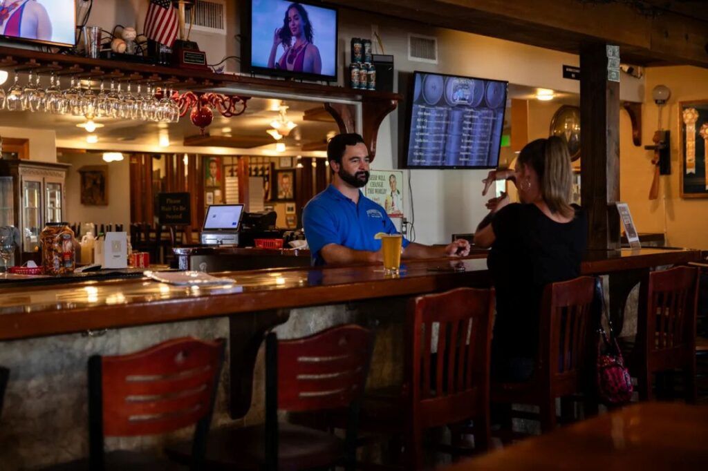 Image of a bartender with a customer at a craft brewing bar and eatery