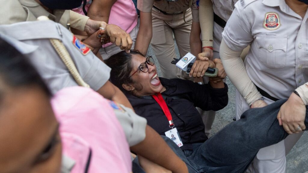Security personnel detain a journalist during a protest by the Cockroach Janta Party (CJP) seeking the resignation of India's Chief Election Commissioner Gyanesh Kumar, near the protest site in New Delhi, India, October 11, 2026. REUTERS/Adnan Abidi