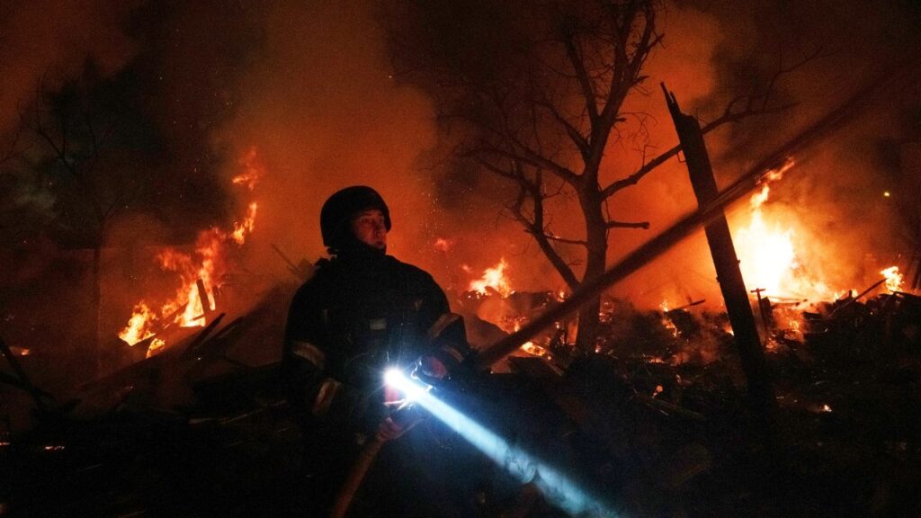 Image of a Ukrainian firefighter with a flashlight at the scene of a Russian aerial strike