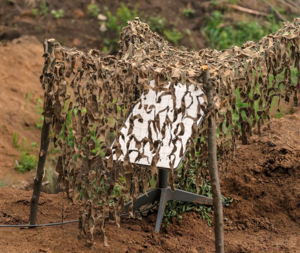 Image of a Starlink terminal in the Ukraine countryside covered by a camouflage net