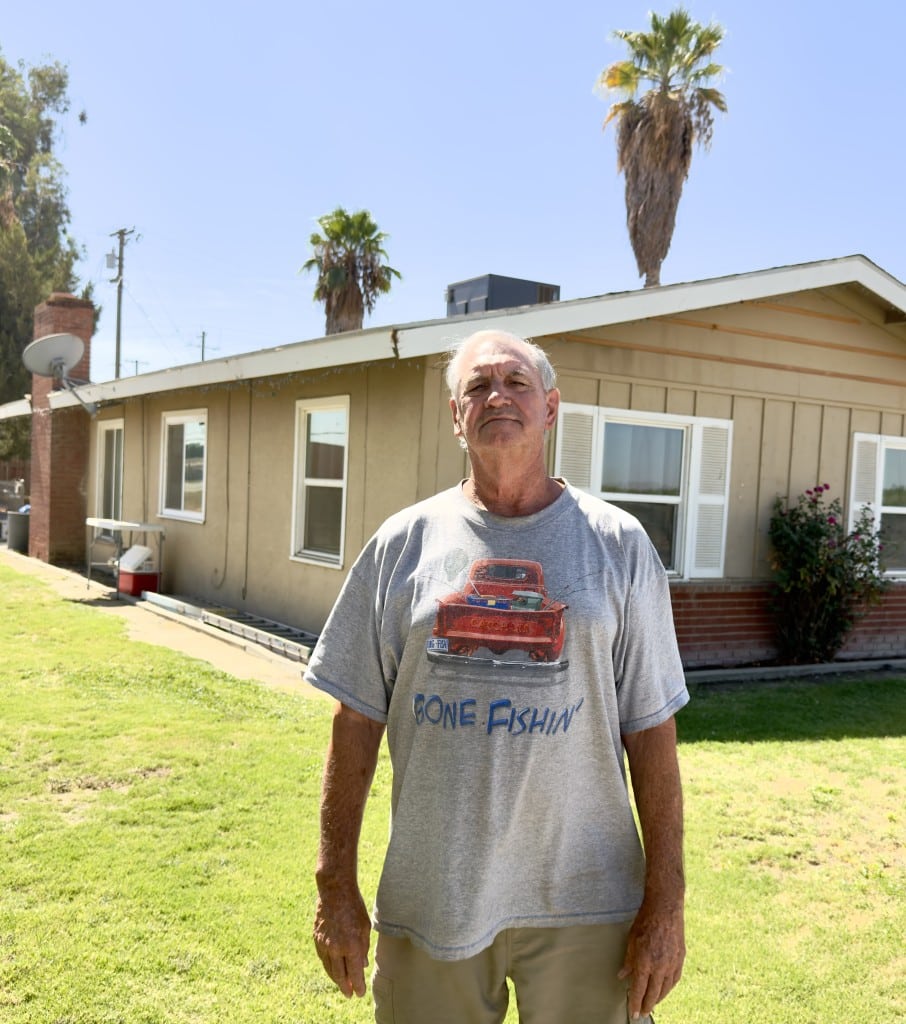 Image of a man in a t-shirt standing in front of a home in the Kern County community of Pond