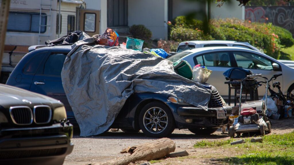 Image of a car that homeless people appear to be living in
